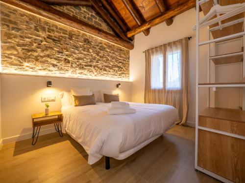 a bedroom with a large bed and a stone wall at mu APARTAMENTOS RURALES in Albella