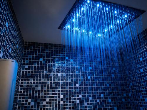 a bathroom with a blue shower with lights on it at Hotel & Spa La Salve in Torrijos