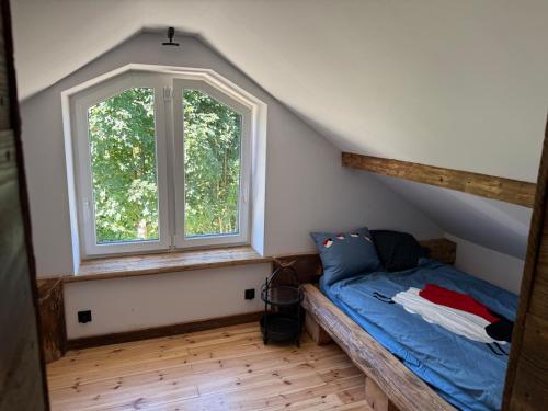 a bedroom with a bed and a large window at Kachlówka in Lachowice