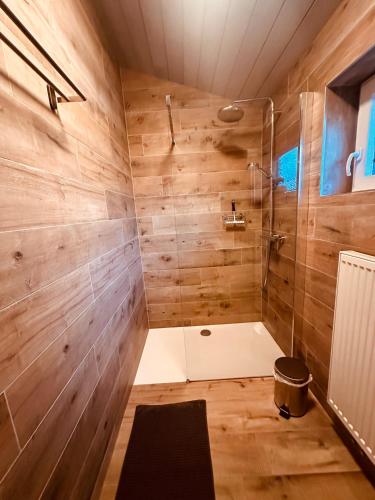 a bathroom with a shower with wooden walls at Chalet des Campanules avec Sauna in Vielsalm