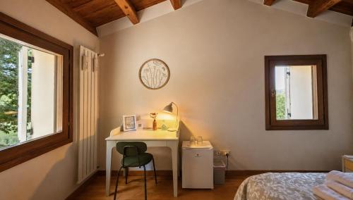 un dormitorio con escritorio, cama y ventana en B&B Villa Euganea, en Torreglia