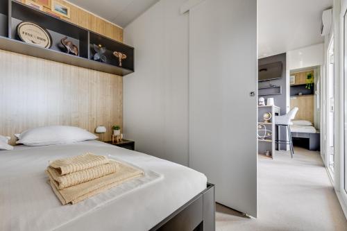a bedroom with a large white bed with a wooden wall at Mobile Home Altura Luxury Sea View Retreat in Drage