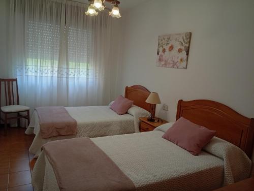 a hotel room with two beds and a window at Piso centro de Raxò in Raxó