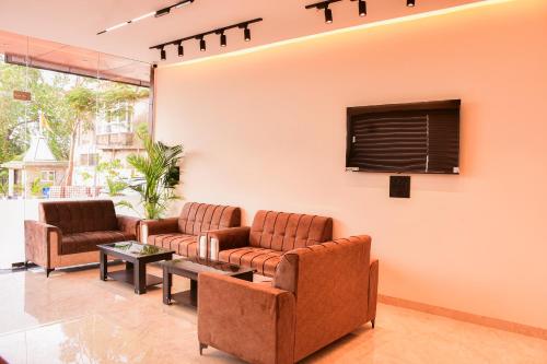 a waiting room with couches and a tv at Mandu's Green Valley Resort in Māndu