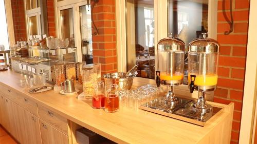 a counter with glasses and bottles of orange juice at Hotel Central in Zeven