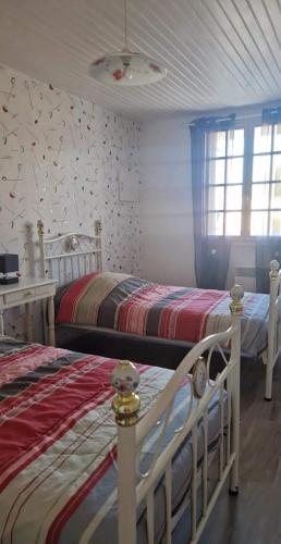 a bedroom with two beds and a window at L'escapade in Rétaud