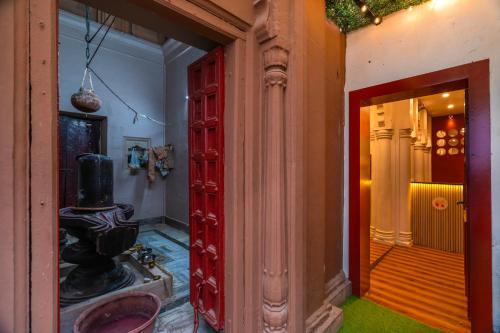 a room with a red door and a hallway at Madpackers Varanasi in Varanasi