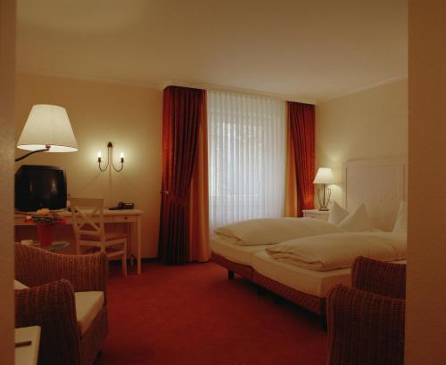 a hotel room with a large bed and a desk at Hotel Central in Zeven