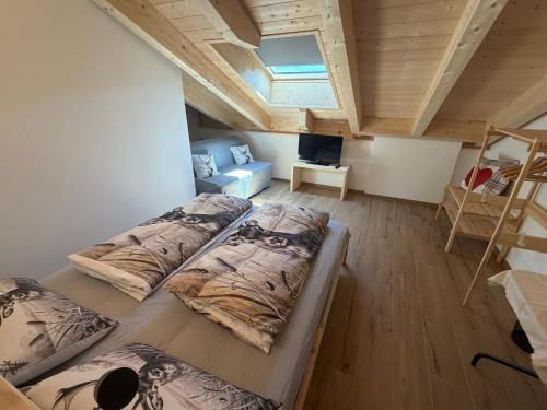 three beds in a room with a loft at Dalla zia Gemma in Carano