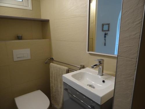 Un baño con lavabo, inodoro y espejo. en Villa 8 au Village Marin, en Porto Vecchio
