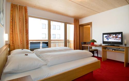 ein Hotelzimmer mit 2 Betten und einem TV in der Unterkunft Apart Marienberg in Lermoos