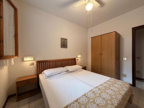 a bedroom with a bed and a wooden cabinet at Residenza Emilia in Lido degli Estensi