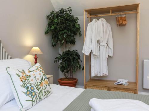 a bedroom with a bed and a robe hanging on a wall at Captains Barn in Tiverton