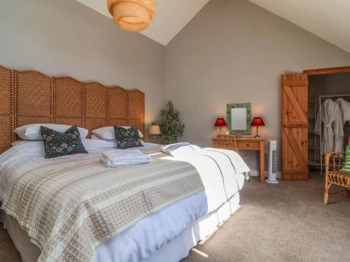 a bedroom with a large bed with a wooden headboard at Captains Barn in Tiverton
