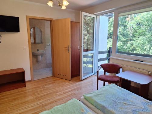 a bedroom with a bed and a bathroom with a shower at Pokoje Gościnne Kalina in Łagów