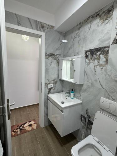 a bathroom with a white toilet and a sink at Arval Rooms in Vlorë