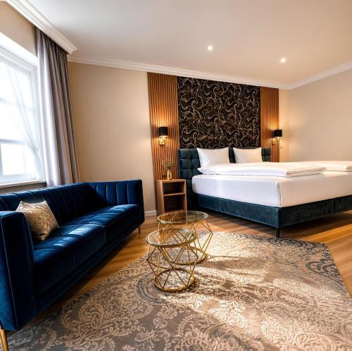 a hotel room with a bed and a couch at Gasthof Russenbräu in Tiefenbach