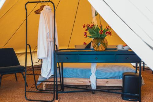 a blue table with flowers on it in a tent at B&B 't Hoogste Kamers en Glamping in Bornem