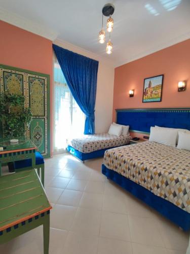 a hotel room with two beds and a window at Hotel Maamoura in Casablanca