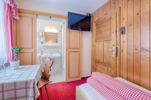 a room with a bed and a bathroom with a sink at Walch's Camping & Landhaus in Braz