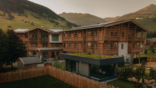 a large building with a fence in front of it at FRÄULEIN NANNERL - Boutique Apart mit Saunahaus in Gerlos