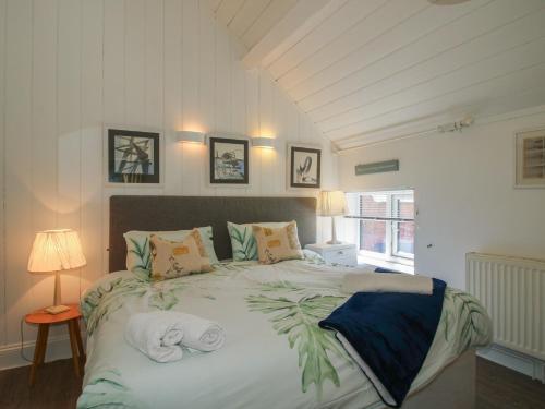 a bedroom with a large bed with towels on it at Chess Cottage in Hereford