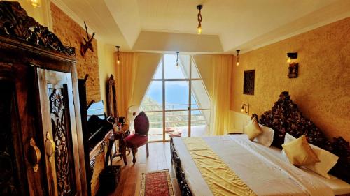 a bedroom with a large bed and a large window at Kali Tibba Resort Chail in Chail