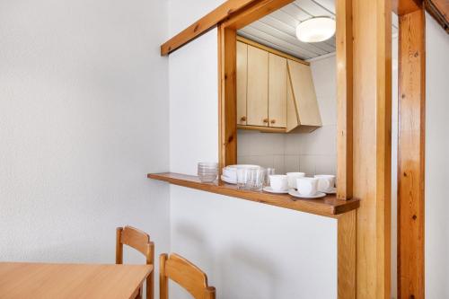 a kitchen with a counter with cups and a table at TRH Jardín Del Mar in Santa Ponsa