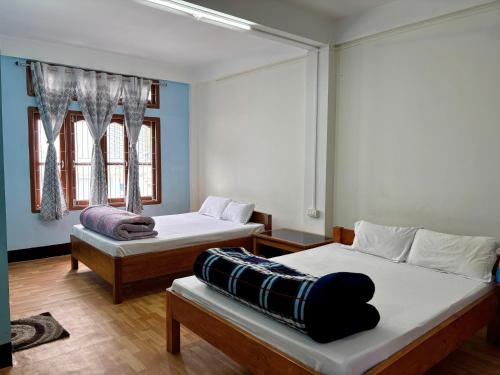 two beds in a room with blue walls at Tenzin Homestay in Dirang Dzong