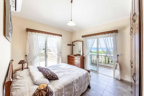 a bedroom with a bed and a large window at Villa Vasilissa in Argaka