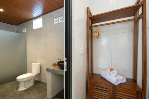 a bathroom with a toilet and a sink at Sari Bungalow in Ubud