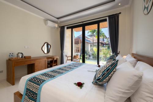 a bedroom with a large white bed with a window at Sari Bungalow in Ubud