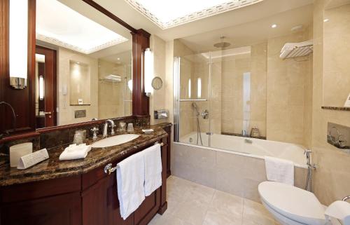 La salle de bains est pourvue d'un lavabo, d'une baignoire et de toilettes. dans l'établissement Hôtel Napoleon Paris, à Paris
