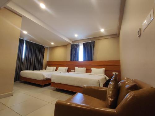 a hotel room with two beds and a couch at CR RIVERA in Madurai