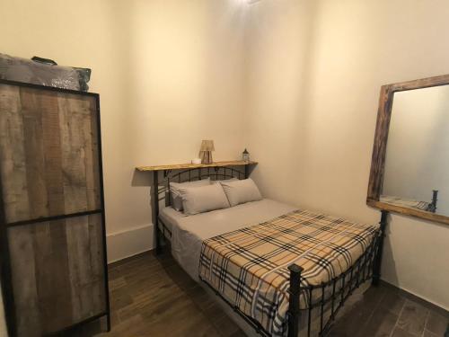 a small bedroom with a bed and a mirror at Helidoni in Margarítai