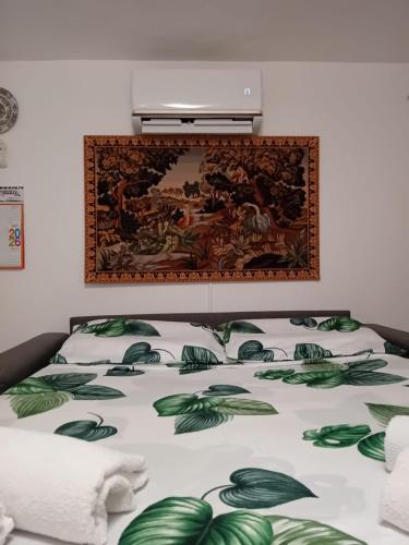 a bed with a painting on the wall above it at LV SWAN Apartment in Carloforte
