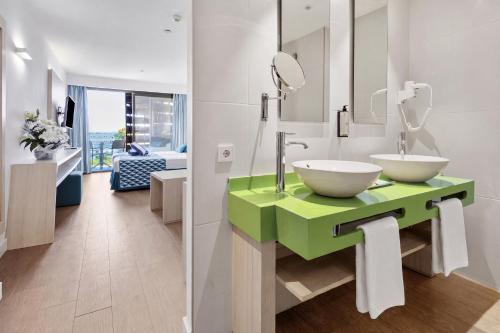 a bathroom with a green counter with two sinks at Hotel Luxor in Playa de Palma