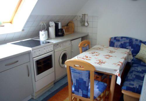 a kitchen with a table and a washing machine at Apartment kleine Robbe in Büsum