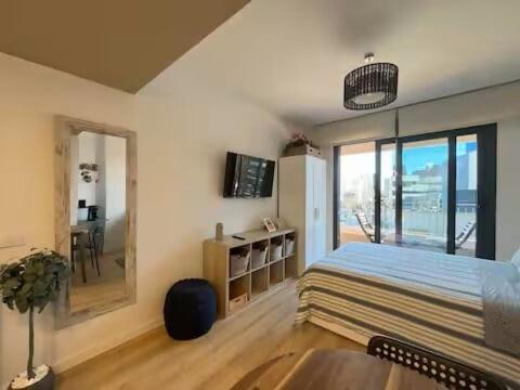 a bedroom with a bed and a table and a window at Studio Home Madrid in San Sebastián de los Reyes
