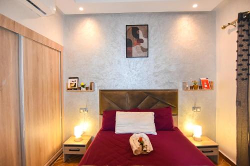 a bedroom with a red bed with two night stands at Martil , Lieu tranquille avec piscine in Martil