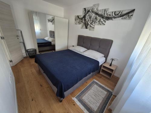 a bedroom with a large bed and a mirror at Apartman Malomi in Solin