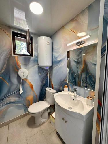 a bathroom with a toilet and a sink at Бунгала " SEA VILLAGE DAR " in Kamchia