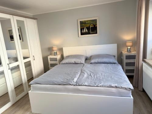 a white bed with two pillows in a bedroom at Ferienwohnung am Binnensee 2 in Heiligenhafen