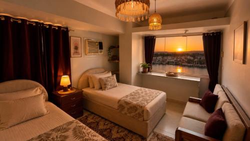 a bedroom with a bed and a window and a couch at Anuket House in Naj‘ al Maḩaţţah