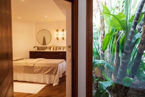 a hotel room with a bed and a bathroom at Grand Hôtel De Cala Rossa & Spa Nucca in Porto-Vecchio