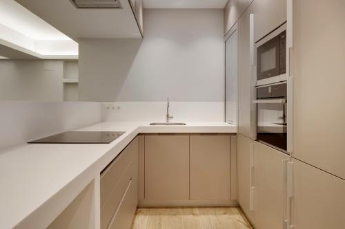 a kitchen with white cabinets and a sink and a stove at Bella Easo 3 by FeelFree Rentals in San Sebastián