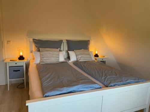 a bed in a room with two tables and two lamps at Burgerblick in Brodersby