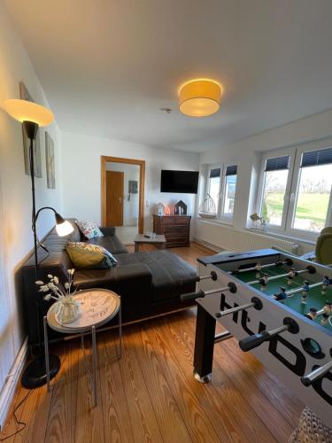 a living room with a couch and a pool table at Burgerwiese in Brodersby