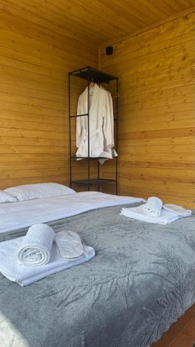 a large bed with towels on a wooden wall at Lunara Chalet in Kazbegi