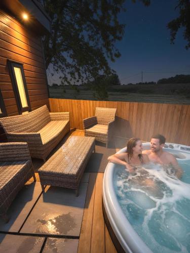 a man and woman in a hot tub on a patio at Hideaway by Liv Retreats in Lincoln